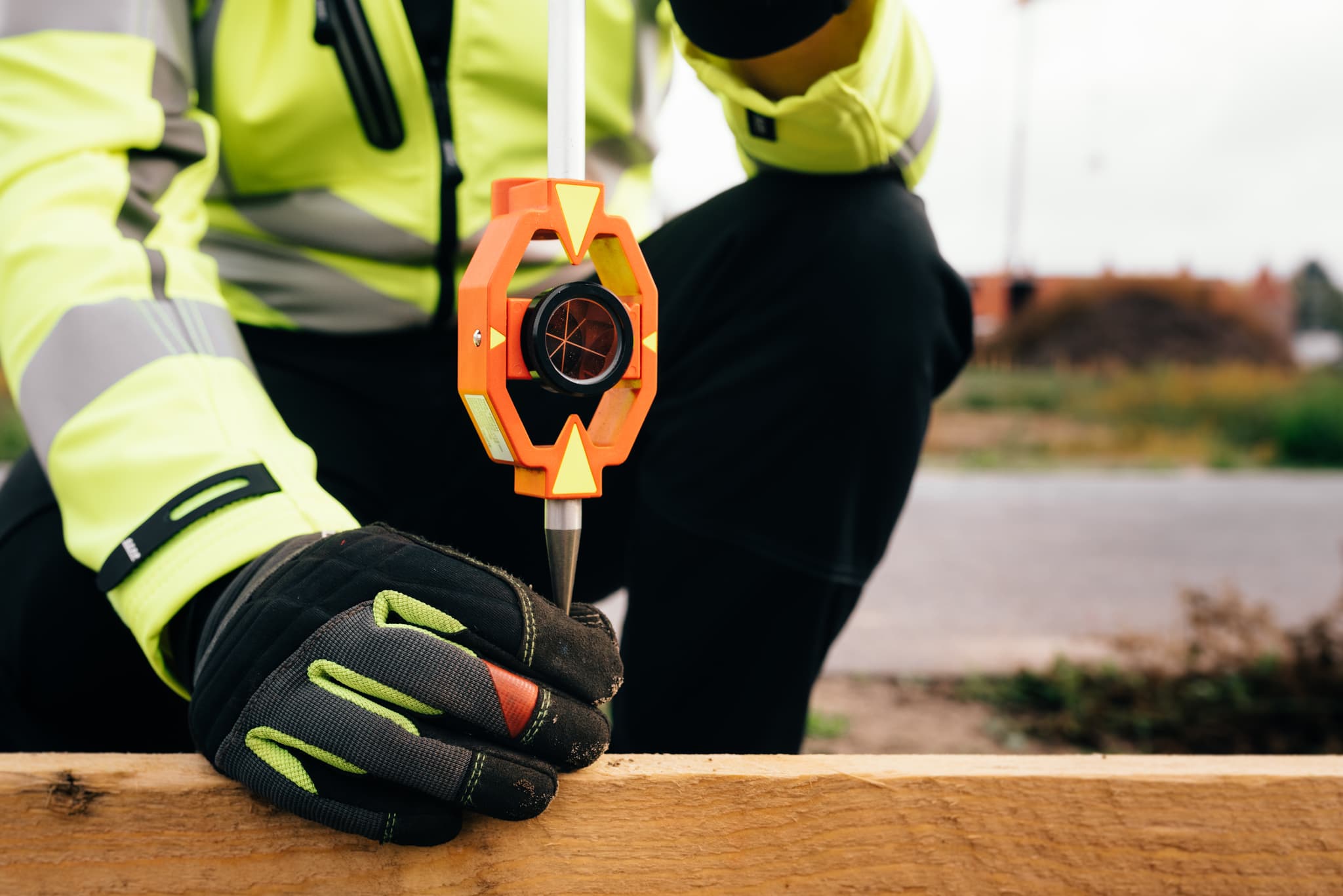 Landmeter zet een bouwlijn uit met behulp van een miniprisma