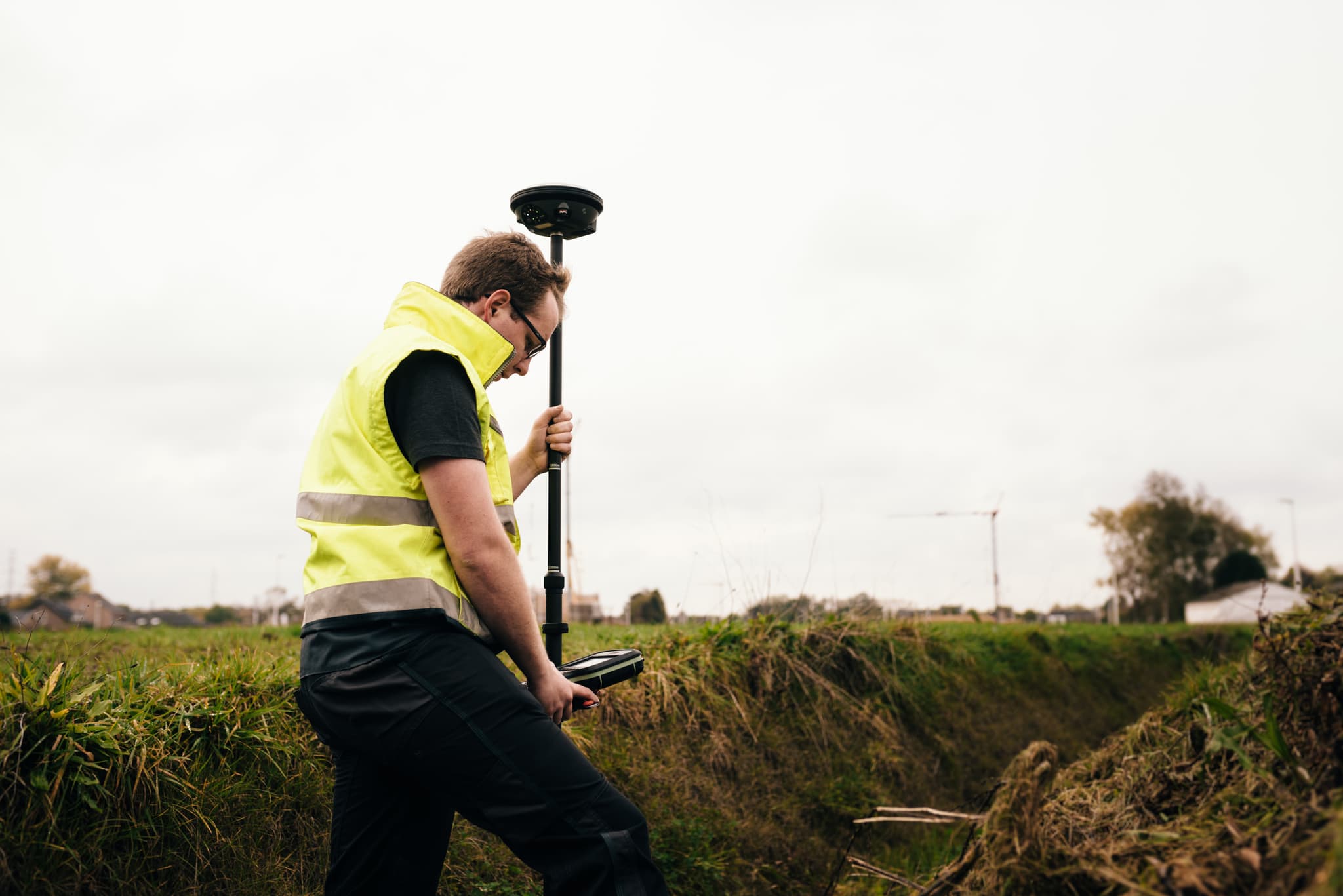 Landmeter voert GNSS-meting uit op het terrein