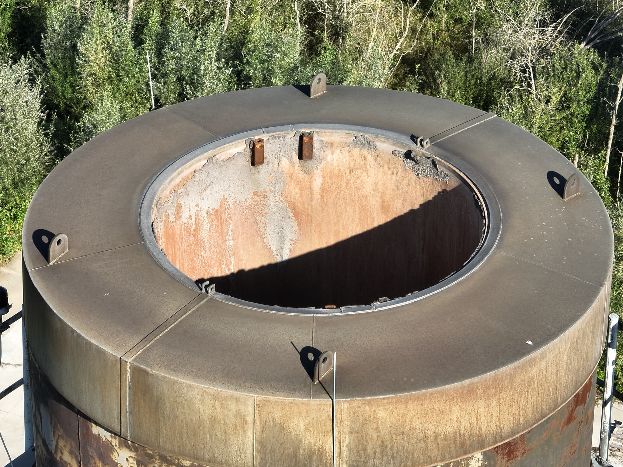 Detailopname van de bovenkant van een industriële tank met roestschade