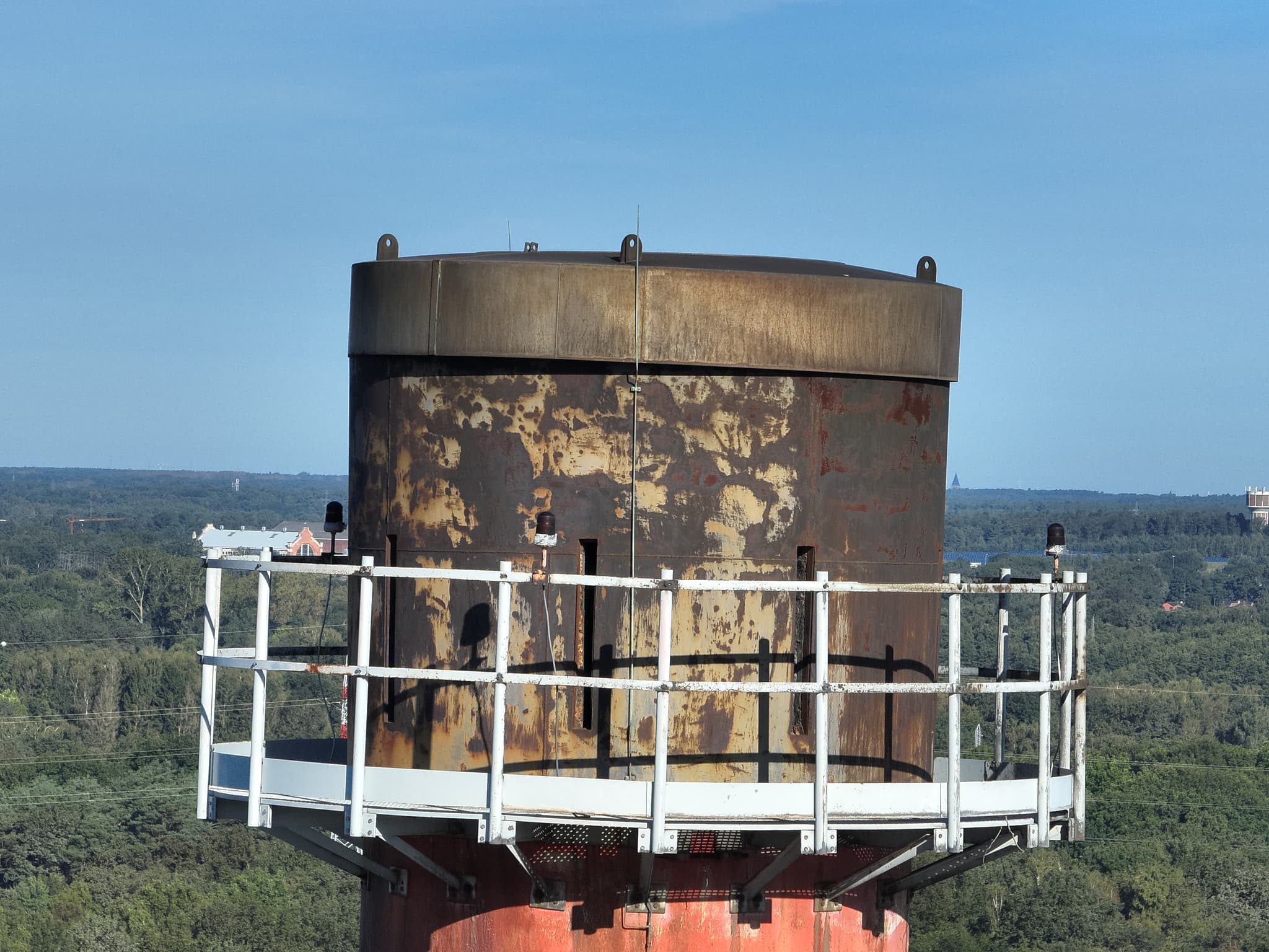 Detailopname van een verroeste industriële toren met loodbrug vanuit de drone