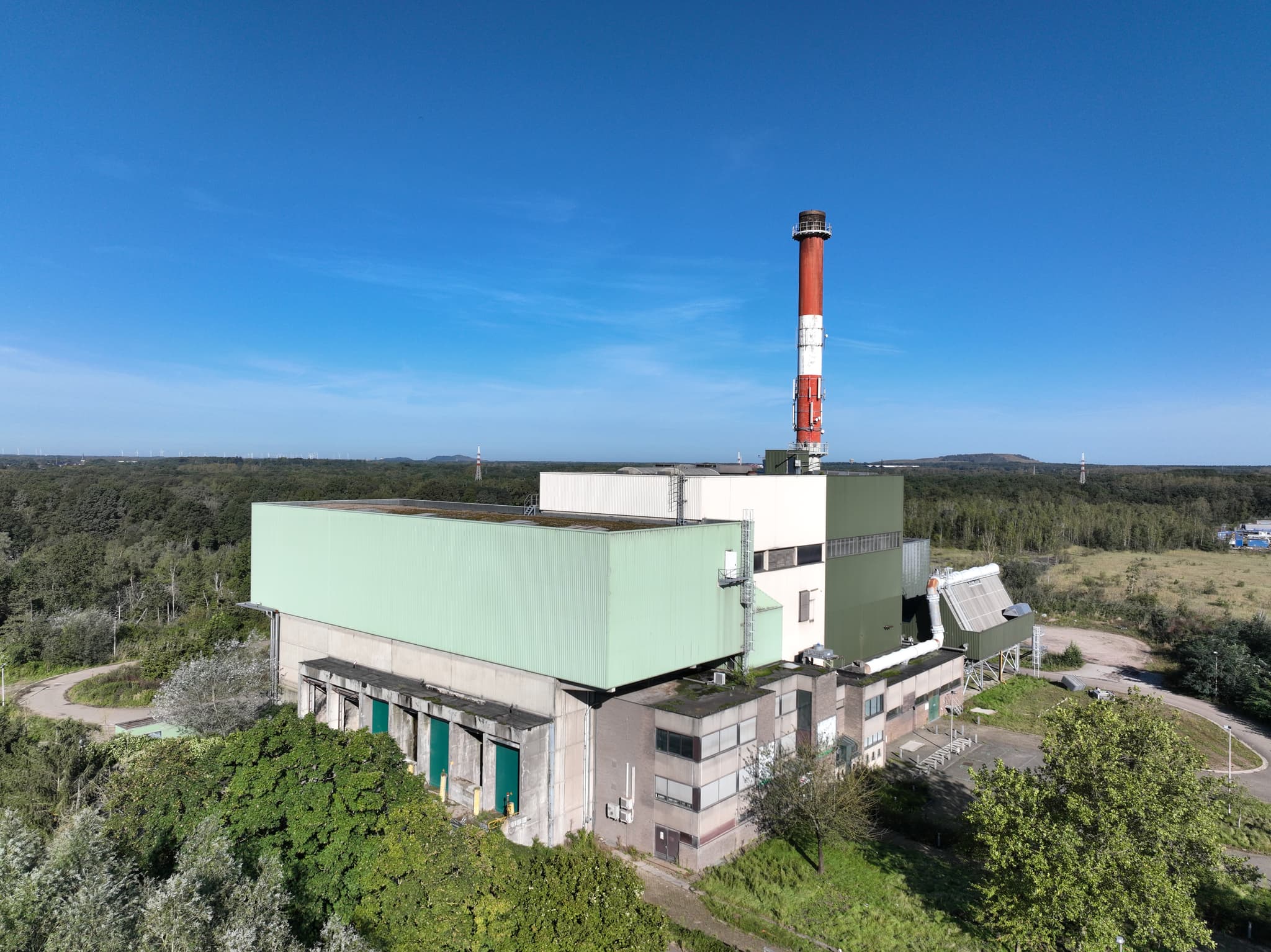 Overzichtsopname van een industrieel gebouw met schoorsteen vanuit de lucht